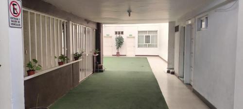 a hallway of an office building with a green carpet at Hotel Avenida Ixmiquilpan in Ixmiquilpan