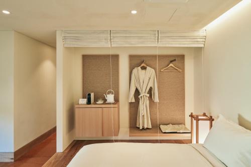 a bedroom with a bed and a robe on a hanger at IJE Gyeongju in Gyeongju