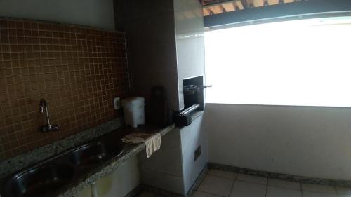 a bathroom with a sink and a water dispenser at Casa Praia 1000 - Guriri Norte in São Mateus