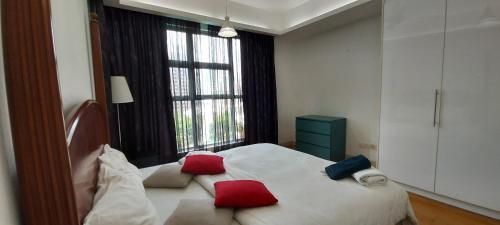 a bedroom with a bed with red and blue pillows on it at 3 Bedroom Cozy apartmet in Kuala Lumpur