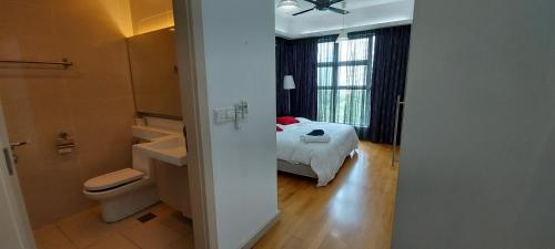 a bathroom with a toilet and a bed in a room at 3 Bedroom Cozy apartmet in Kuala Lumpur