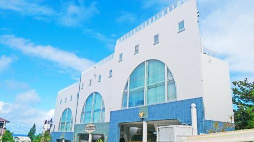 a white building with large windows on the side of it at Coral Garden 7 Pools in Yomitan