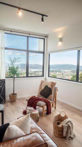 a living room with a couch and large windows at Amazing view Architech Home 8Minutes to Hobart CBD in Hobart