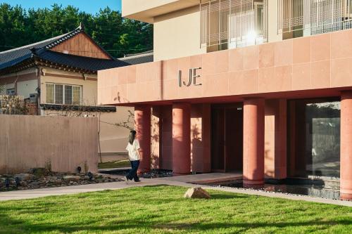 a woman walking in front of a building at IJE Gyeongju in Gyeongju