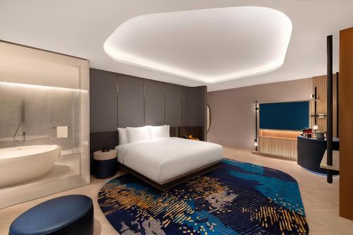 a bedroom with a bed and a bath tub and a bathroom at Hotel Indigo Anji in Anji