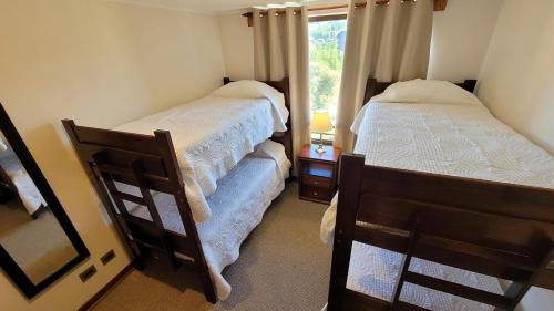 a small bedroom with two beds and a window at La Puntilla in Villarrica