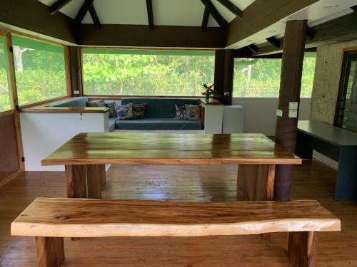 a living room with a wooden table and a couch at Fiji Fishing Holiday Bure in Savusavu