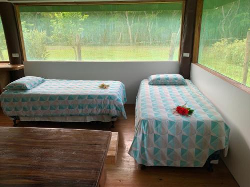 two beds in a room with a window at Fiji Fishing Holiday Bure in Savusavu