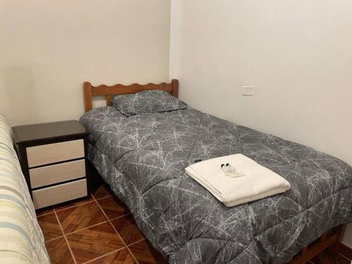 Habitación pequeña con cama y mesita de noche en Apartamento a 10 min del centro de la ciudad, en Huaraz
