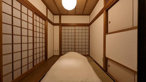 a corridor of a room with white walls and a ceiling at Hokyuann - 邦久庵 in Motogoe