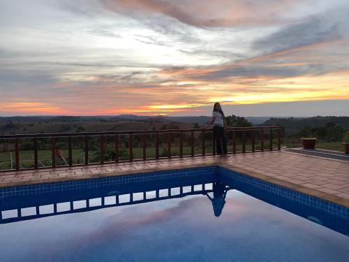 a woman standing on a fence next to a swimming pool at Sumeru in Sen Monorom