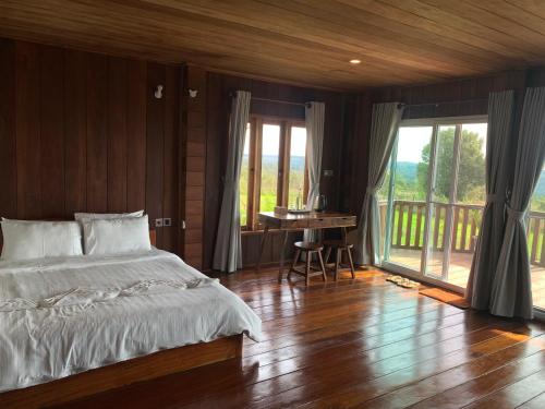 a bedroom with a bed and a desk and a balcony at Sumeru in Sen Monorom