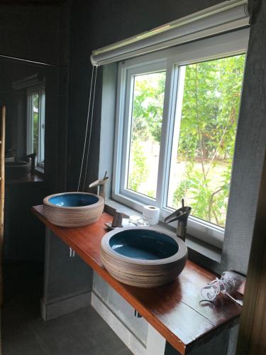 a bathroom with two sinks on a wooden counter with a window at Sumeru in Senmonorom