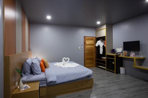 1 dormitorio con 1 cama y escritorio con TV en The Sun resort Ratchaburi en Ratchaburi