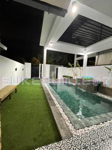 a swimming pool in the backyard of a house at night at sukebumie7 in Shah Alam