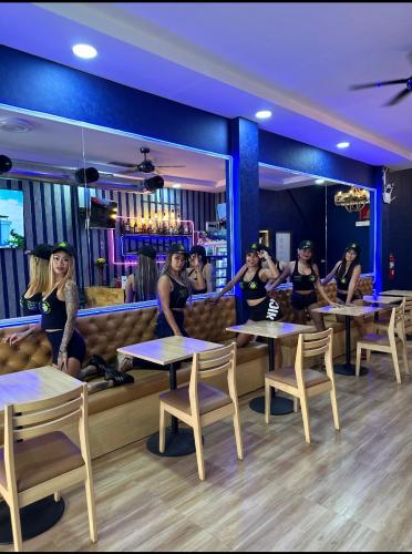 a group of women sitting at tables in a restaurant at Bonkers Guesthouse in Pattaya Central