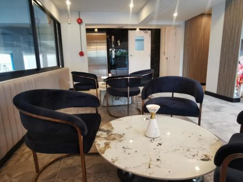 a waiting room with chairs and a table with a vase on it at ABC@48 Hotel & Service Apartment in Bangkok