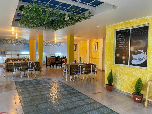 a dining room with tables and chairs in a restaurant at Hostal y Complejo Recreacional La Playita de Monse in Otavalo