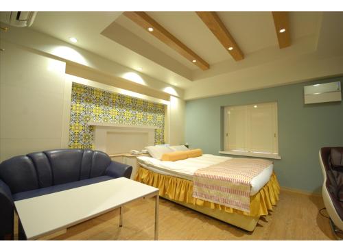a bedroom with a bed and a chair in it at HOTEL K's MINE in Toyota