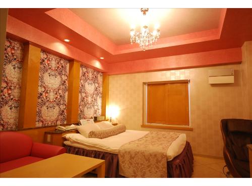 a hotel room with two beds and a chandelier at HOTEL K's MINE in Toyota