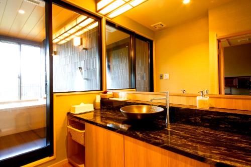 a bathroom with a counter with a sink and a mirror at Kyoto Arashiyama Onsen Ryokan Togetsutei in Kyoto