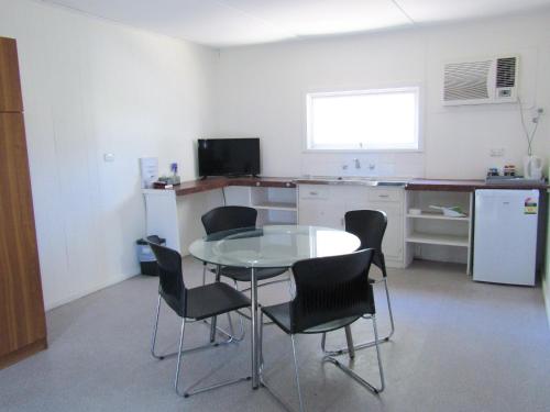 a kitchen with a table and chairs in a room at Tinman Roadhouse in Napperby