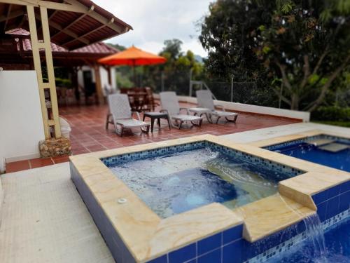 a swimming pool with a table and chairs and an umbrella at FINCA LUNADAR ANAPOIMA in Anapoima