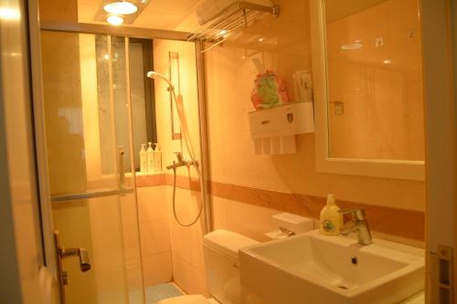 y baño con ducha, aseo y lavamanos. en 悠闲的时光, en Changsha