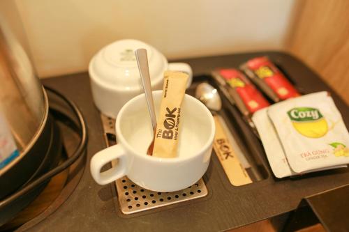 a coffee cup with a spoon in it on a counter at The Bok Hotel Grand World - by GoGo Phú Quốc in Phu Quoc