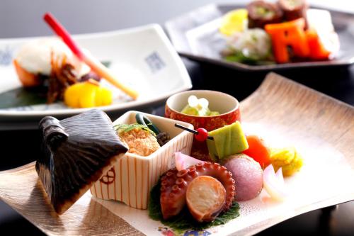 a plate of food with sushi on a table at Kyoto Arashiyama Onsen Ryokan Togetsutei in Kyoto