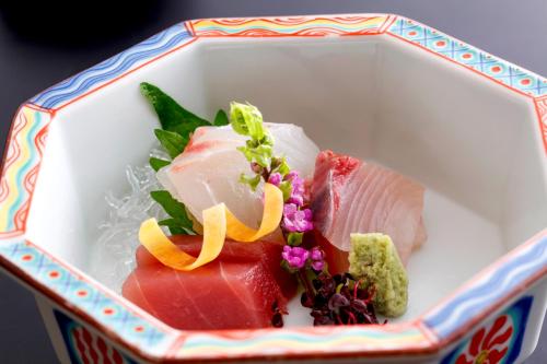 a bowl of food with sushi and vegetables in it at Kyoto Arashiyama Onsen Ryokan Togetsutei in Kyoto