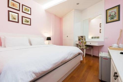 een slaapkamer met een wit bed en een bureau bij Sabai Dee Minitel in Dusit