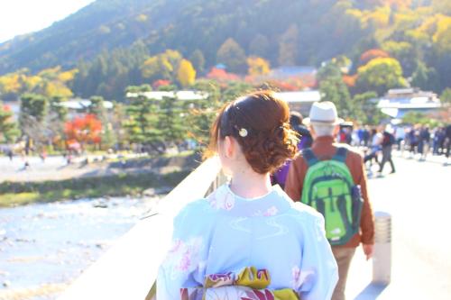 a man and a woman walking down a beach with a surfboard at Kyoto Arashiyama Onsen Ryokan Togetsutei in Kyoto