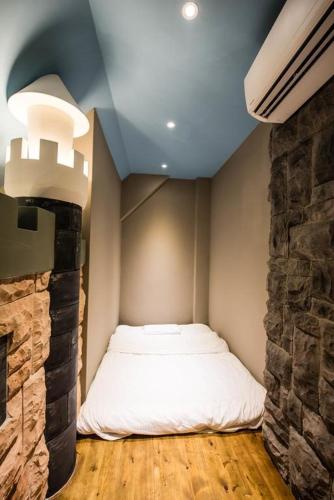 a bed in a room with a stone wall at Hi Kids B&B in Zhixue