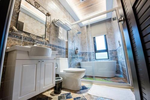 a bathroom with a toilet and a sink and a tub at Hi Kids B&B in Zhixue