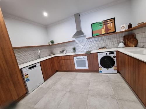 a kitchen with a washer and dryer and a sink at The Sherwood Hotel in Lismore