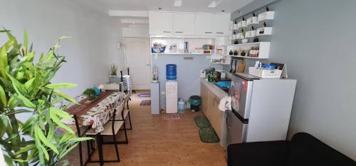 uma cozinha com um frigorífico, uma mesa e cadeiras em San Remo Oasis em Cebu