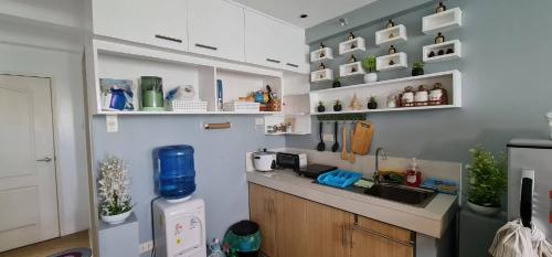 uma cozinha com um balcão, um lavatório e um frigorífico em San Remo Oasis em Cebu