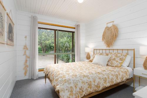 une chambre avec un lit et une fenêtre dans l'établissement The Beach Cottage, à Wye River