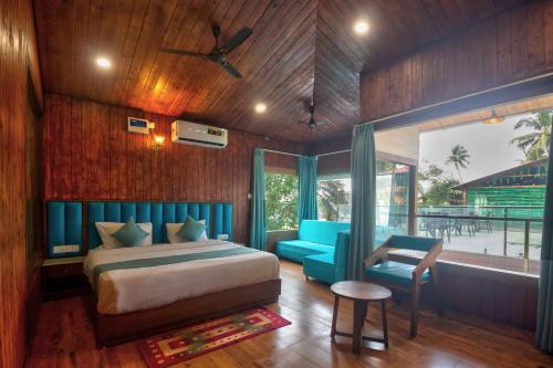a bedroom with a bed and a chair and a window at Oceano Beach Resort in Arambol