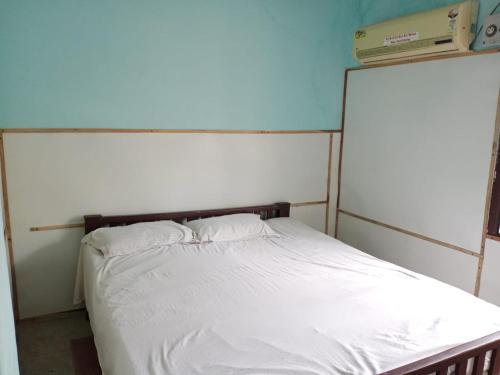 a bedroom with a bed with white sheets at vacation Home Stay in Puducherry