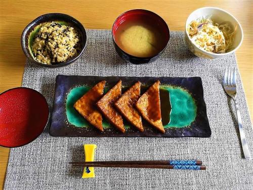 Vegan Minshuku Sanbiki Neko في كيوتو: طبق من الطعام على طاولة مع عيدان الطعام والأرز