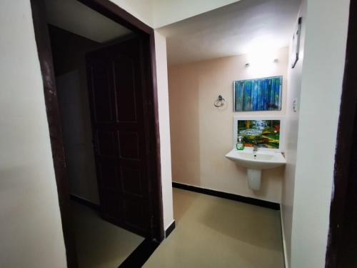 ein Bad mit einem Waschbecken und einem Spiegel in der Unterkunft J2 Home Stay - Luxury Homes with Caravan Services in Thiruvananthapuram