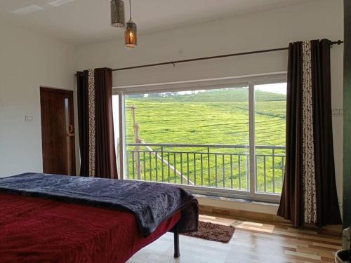 a bedroom with a bed and a large window at Tea Estate view stay in Ooty