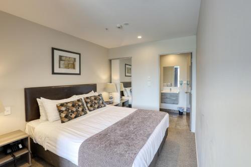 a bedroom with a large bed in a room at Ramada Suites by Wyndham Queenstown Remarkables Park in Queenstown