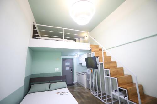 ein Schlafzimmer mit einem Etagenbett und einer Treppe in der Unterkunft LikeU Guest house in Seoul