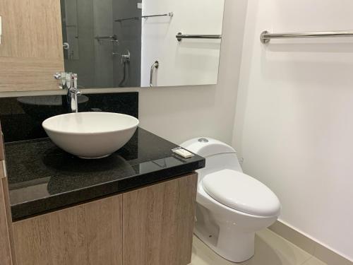 a bathroom with a white toilet and a sink at Bocagrande Infinitum Vista mar Gym Coworking in Cartagena de Indias