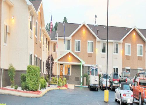 a group of buildings with cars parked in a parking lot at Super 8 by Wyndham South Boston VA in South Boston