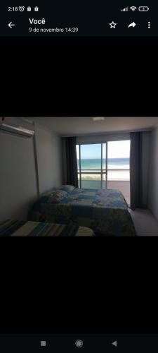 a picture of a bedroom with a bed and a window at apartamento duplex Arraial do Cabo VISTA PARA MAR in Arraial do Cabo