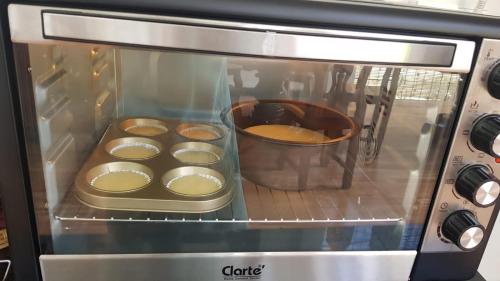 a microwave oven with muffins inside of it at Bloom Garden Bed & Breakfast in Siem Reap